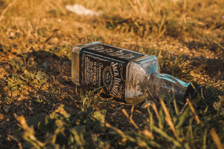 An Empty Bottle Of Jack Daniels On The Ground