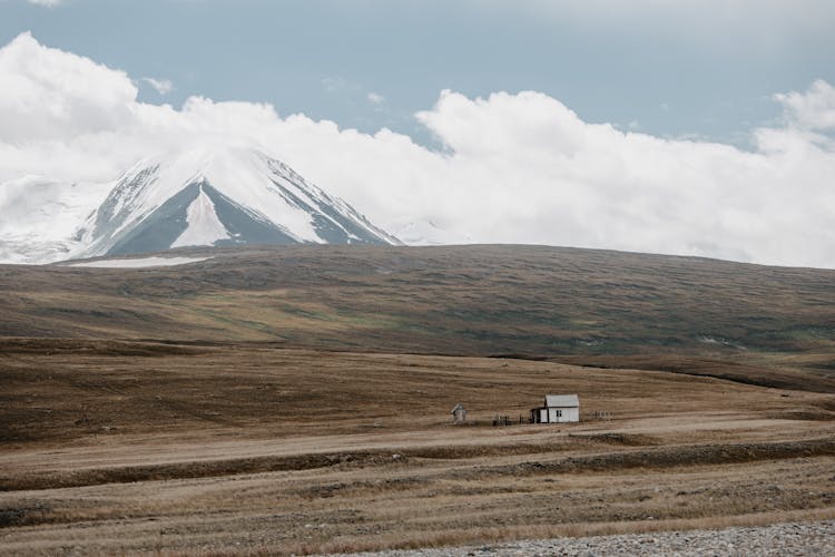 Scenic View Of A House Near The Snowy Mountains