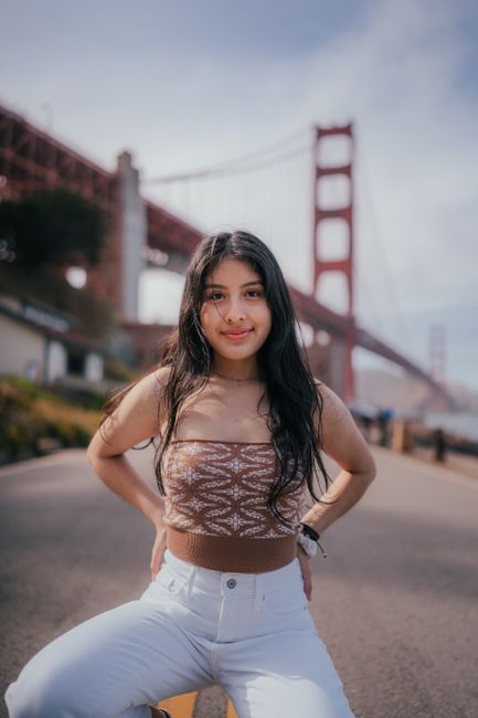 Smiling young woman in tube top posing by the Golden Gate Bridge on a clear day.