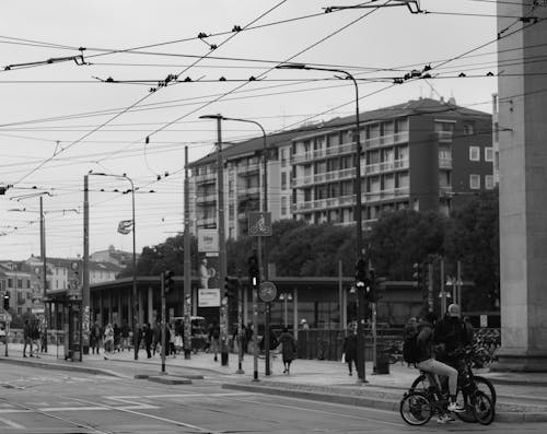 Grayscale Photo of People Walking on Street Near Buildings