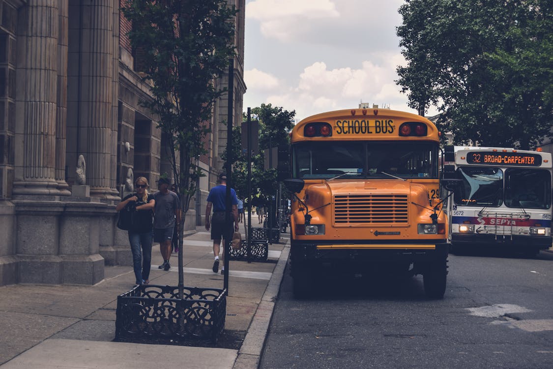 Autobús Escolar Amarillo Junto Al Edificio De Hormigón Gris