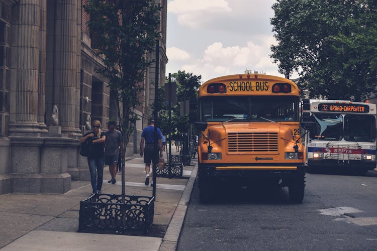 Yellow School Bus Beside Gray Concrete Building