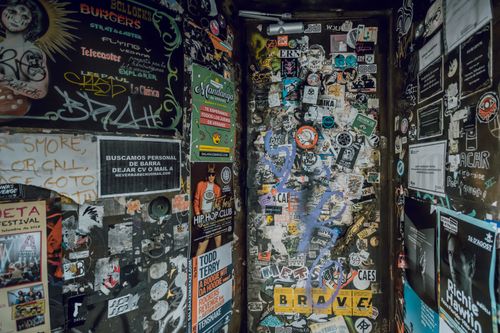Free Eye-catching wall covered with graffiti, stickers, and posters in a Barcelona alleyway. Stock Photo