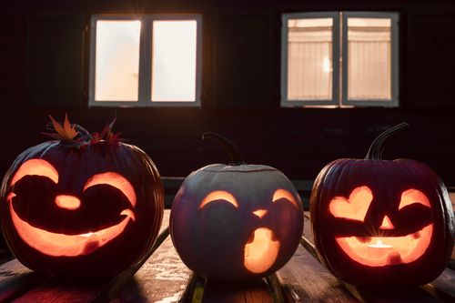 Free Three illuminated jack-o'-lanterns with carved faces, perfect for Halloween ambiance. Stock Photo