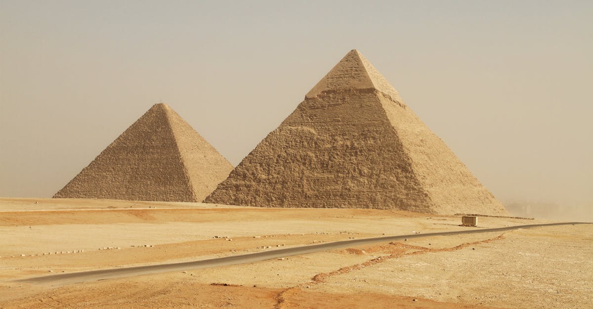 The iconic Giza Pyramids in Egypt stand tall in the desert landscape, showcasing ancient grandeur.