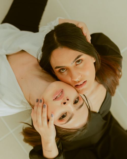 Free Artistic overhead shot of two women lying down, expressing connection and intimacy. Stock Photo