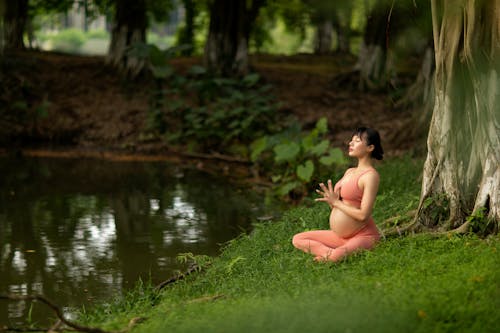 Pregnant Woman Doing Relaxation Exercise by the Lake