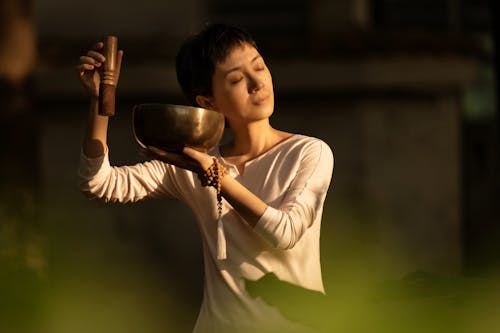 Woman in White Long Sleeve Shirt Holding Stainless Steel Bowl