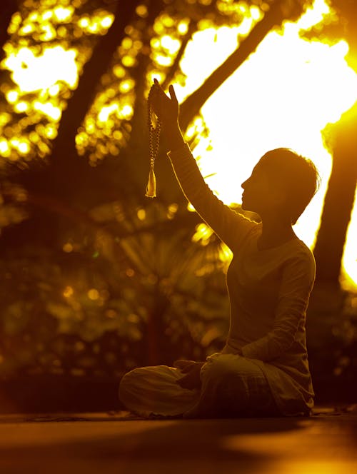 Woman Holding Prayer Beads above Her Head