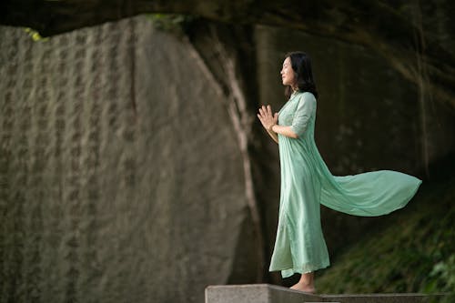 Woman Praying on Ledge 