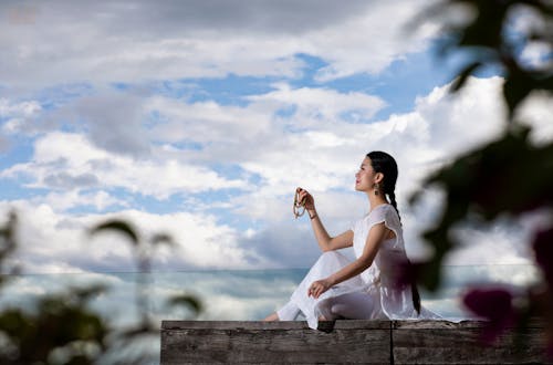 Sitting Woman Holding Prayer Beads