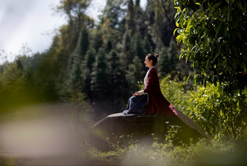 Woman in Traditional Costume Meditating in Nature