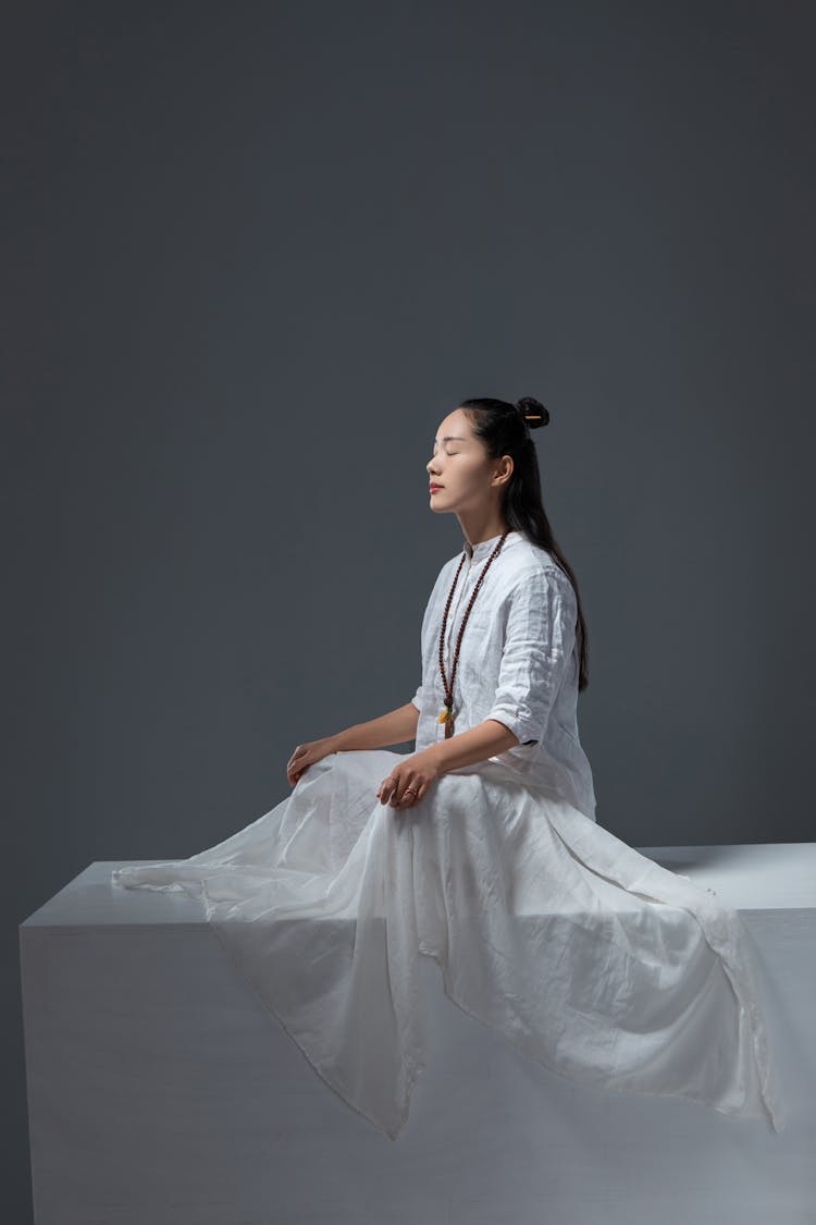 Man With Long Hair Meditating While Sitting Cross-Legged