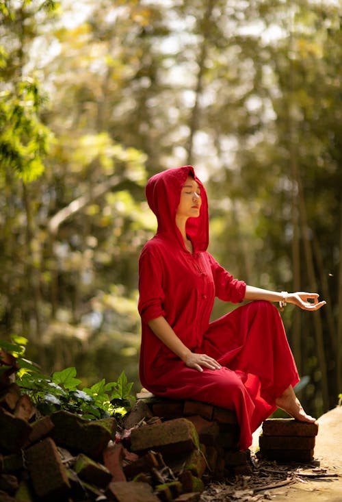 Woman Wearing a Gown Sitting in the Forest and Meditating 