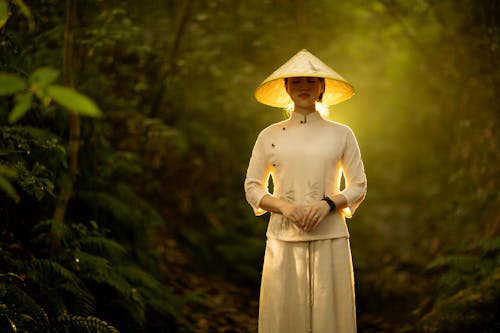 A Woman in White Long Sleeve Dress Wearing Brown Conical Hat 