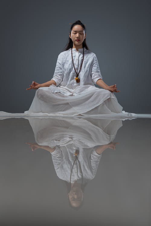 A Woman in White Dress Meditating