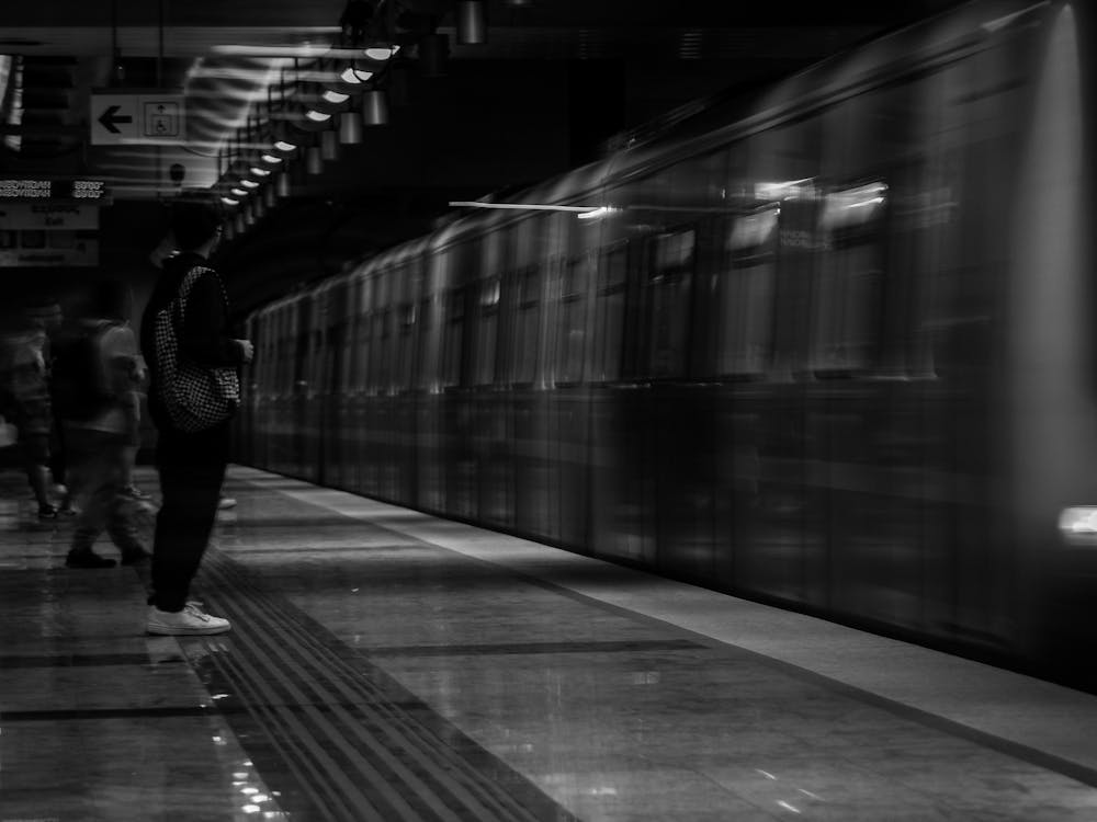 Grayscale Photo of People on Train Station