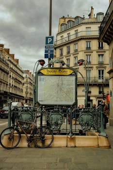 Paris street view featuring Louvre-Rivoli metro entrance under cloudy skies.