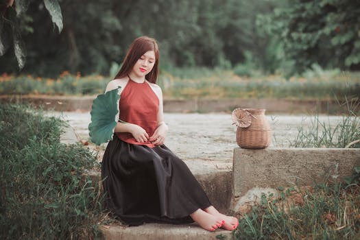 一位亚洲女性在大自然中优雅地手持一片树叶和一个柳条篮，宁静而安详