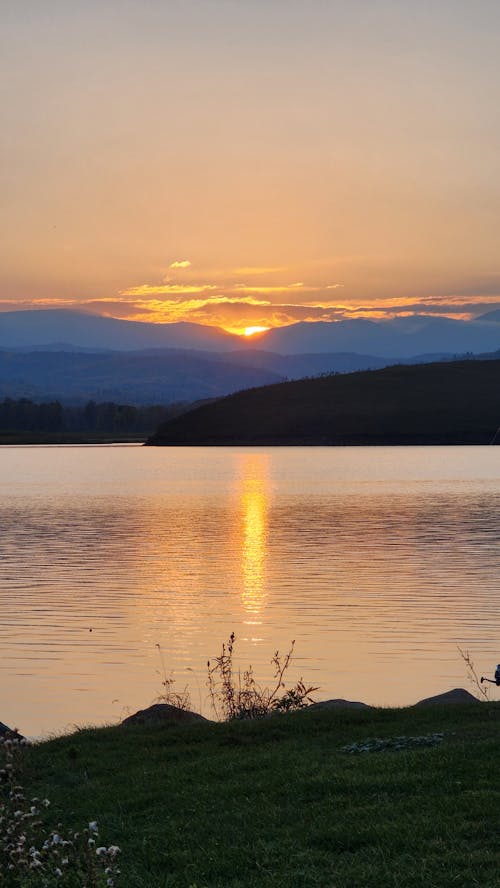 Body of Water Near Mountain during Sunset