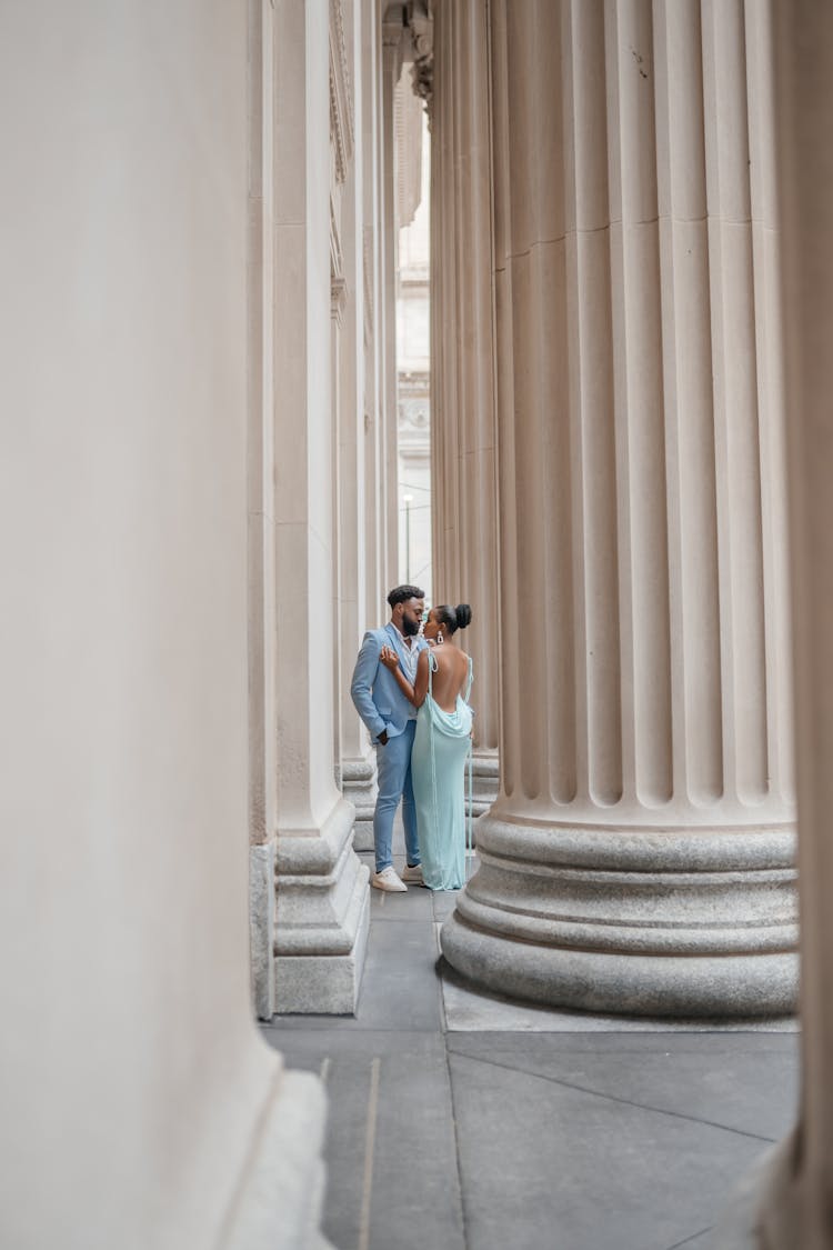 Couple Posing Near Bedrocks Of Old Building 