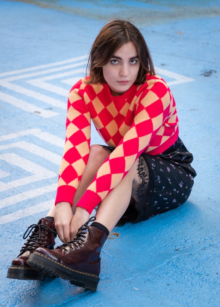 A Woman Wearing A Sweater And Black Boots 