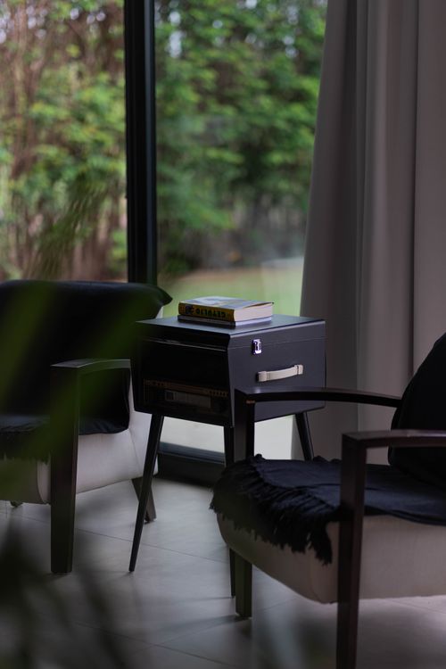 Free Cozy living room with modern armchairs, a side table, and a view through the window. Stock Photo