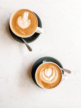 Elegant cappuccinos with intricate latte art in ceramic cups, perfect for coffee lovers.