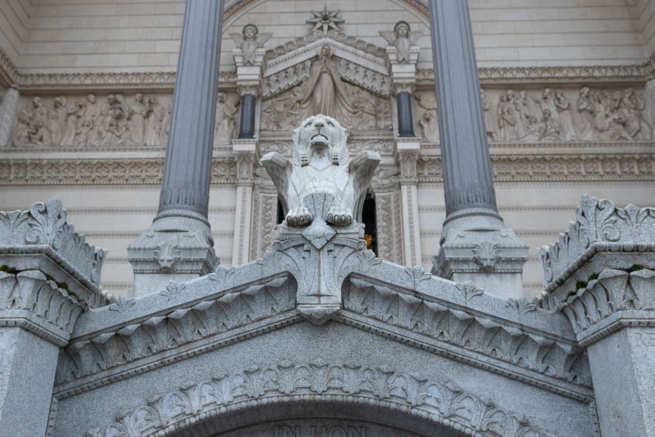 Intricate lion sculpture adorns a historic facade in Lyon, France, highlighting architectural elegance.