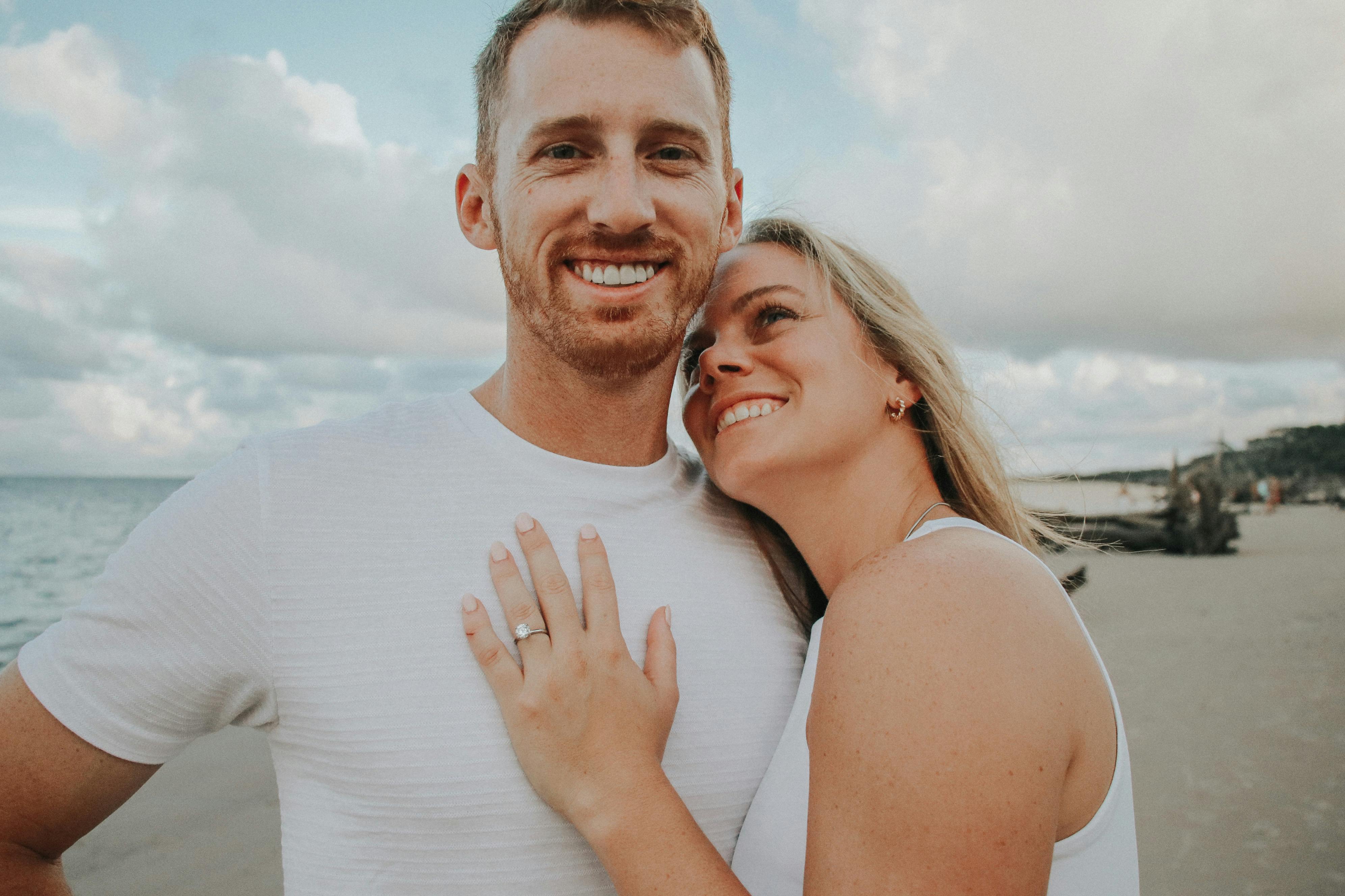 Smiling couple in love enjoying a moment together on a sandy beach.