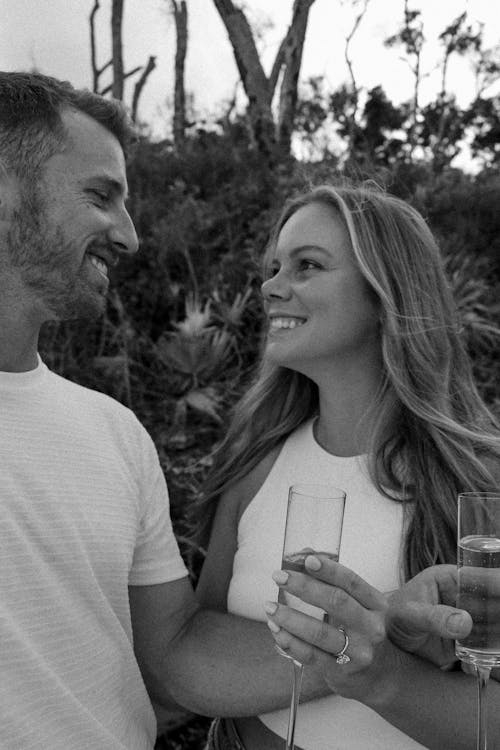Grayscale Photo of Couple Holding Champagne Glasses