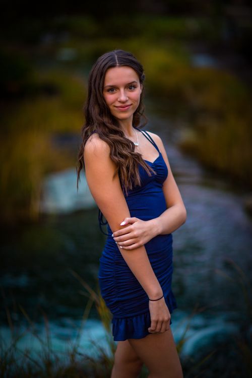 Free Young woman in a blue dress posing gracefully in a serene outdoor setting. Stock Photo