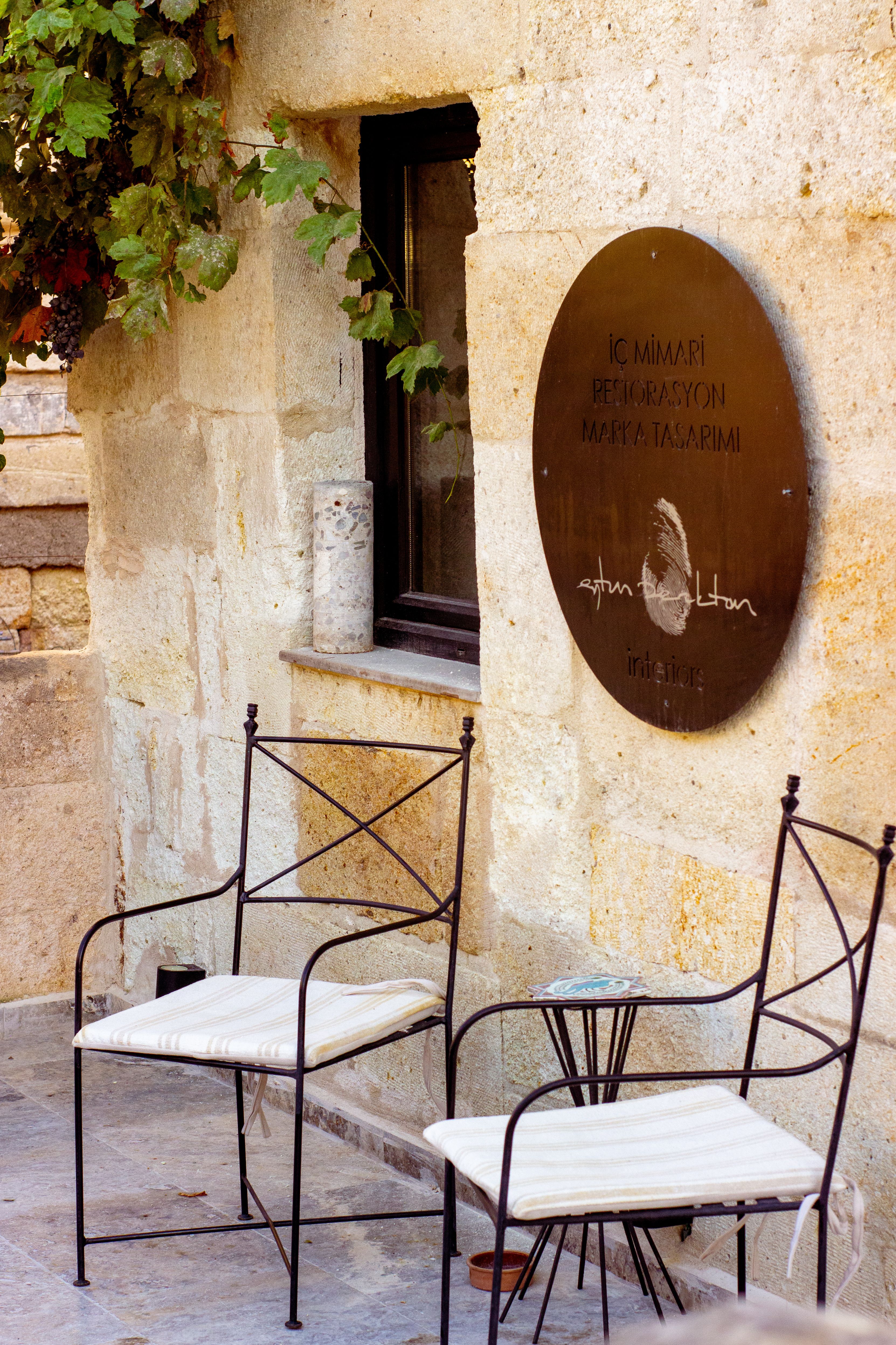 Cozy terrace scene with iron chairs in Ürgüp, showcasing traditional architecture.