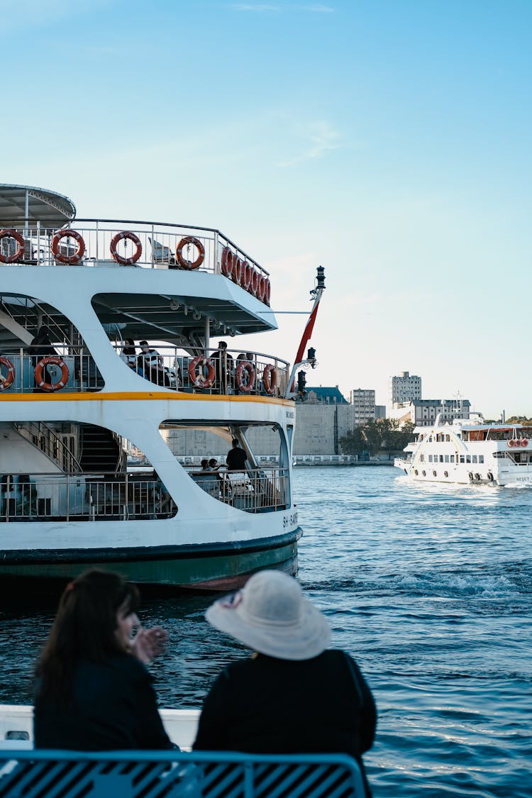 People Enjoying Ferry Ride Sailing On River