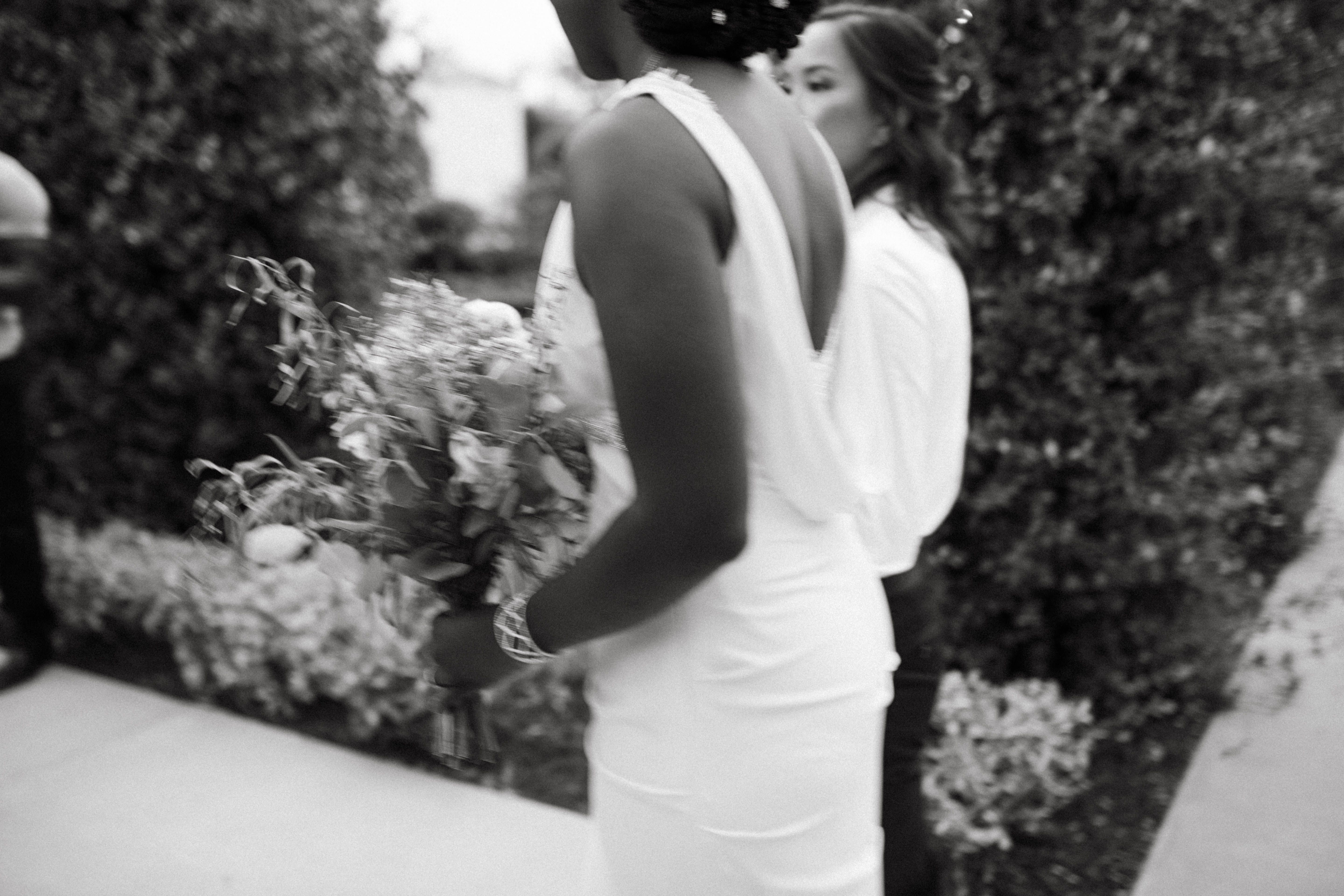 Bride holding a beautiful white rose wedding bouquet in a sunlit garden