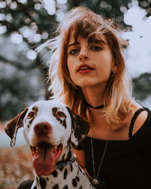 Free A young woman and her Dalmatian enjoying a day outdoors in a natural setting. Stock Photo