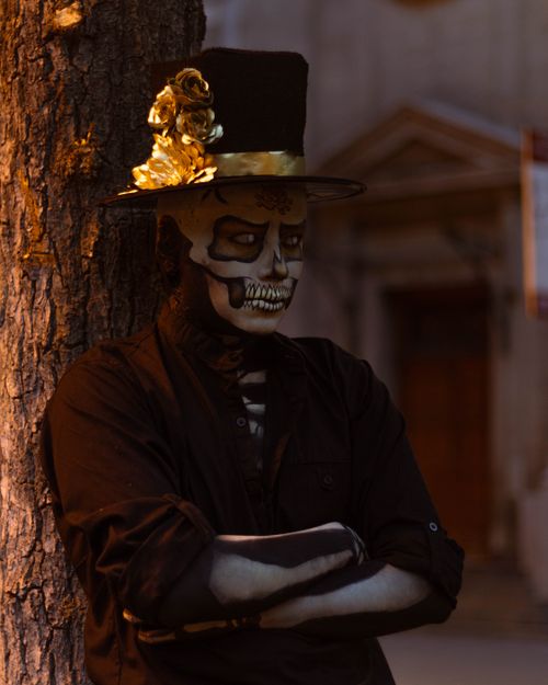 Free Close-up portrait featuring Dia de los Muertos face paint and costume in a traditional setting. Stock Photo
