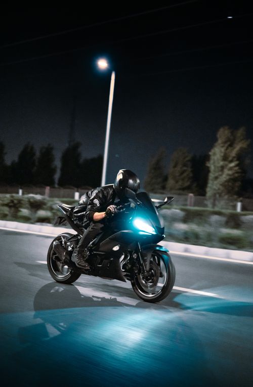 Free Motorcyclist speeds through the night on an open road, showcasing motion blur and dynamic lighting. Stock Photo