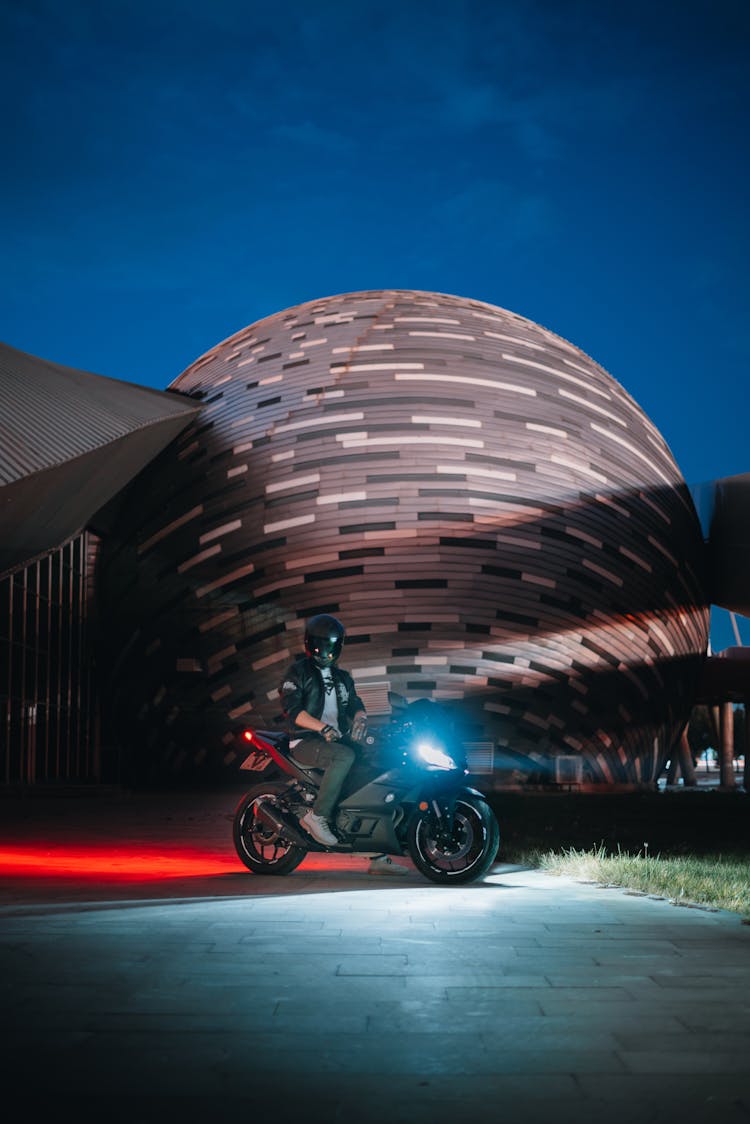 Biker Sitting On A Motorcycle At Night