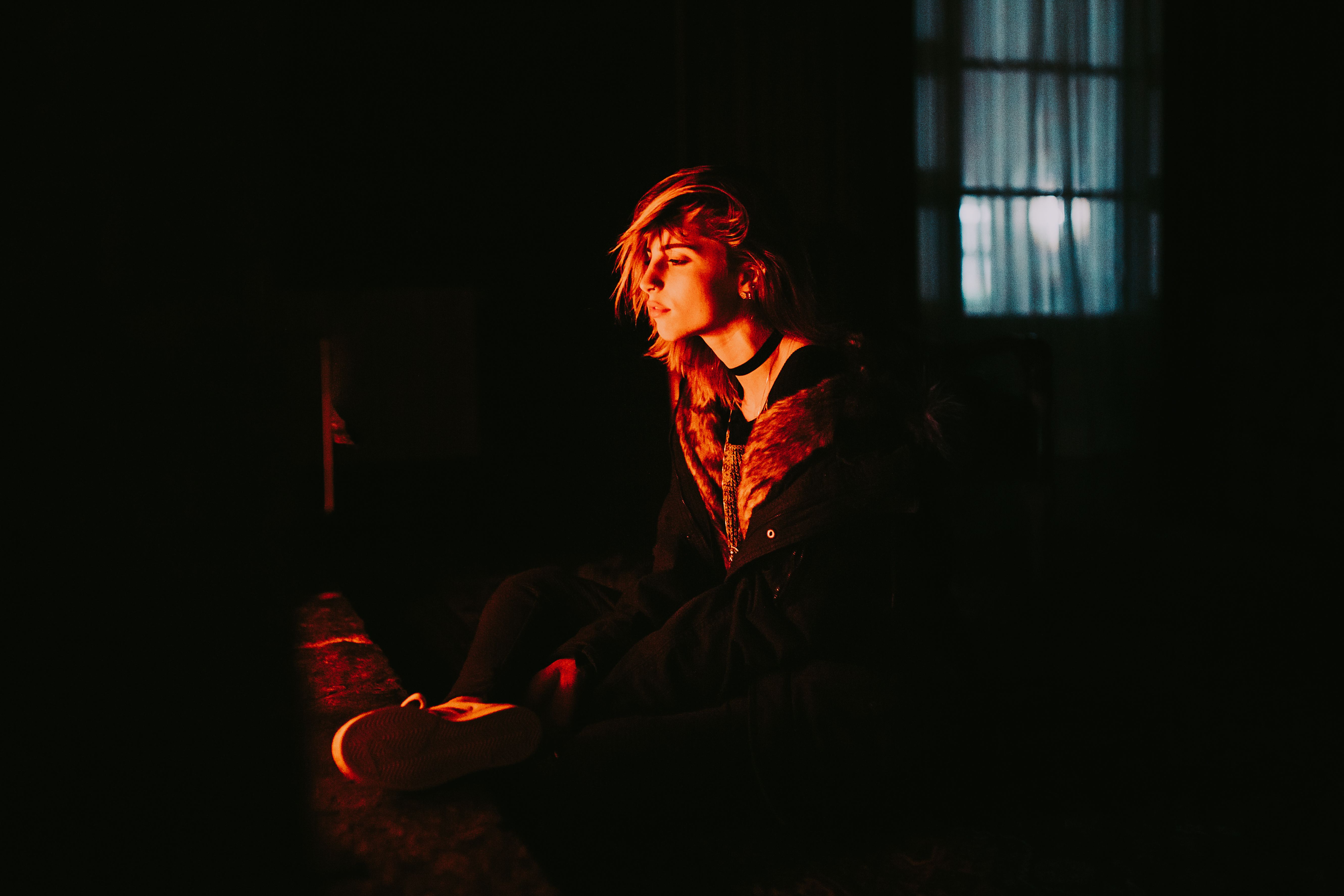 A person sitting alone in a sunlit room with no phone, hands open, soft natural light