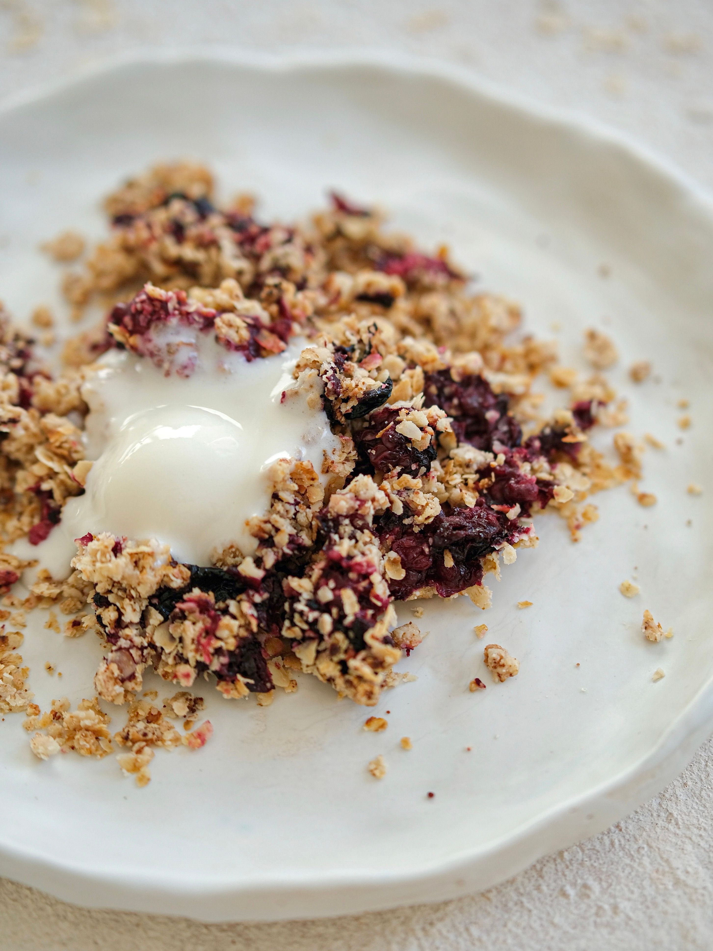 Delicious homemade blackberry crumble served with yogurt topping, perfect for a sweet treat or breakfast.
