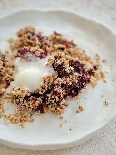 Delicious homemade blackberry crumble served with yogurt topping, perfect for a sweet treat or breakfast.