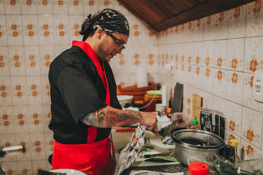 A chef expertly prepares sushi in a traditional kitchen setting, showcasing culinary skills.