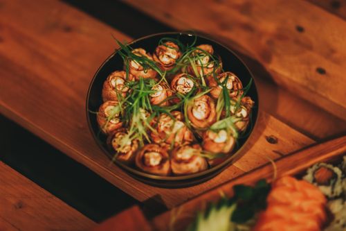 Free Close-up of gourmet appetizers garnished with spring onions on a wooden table. Stock Photo