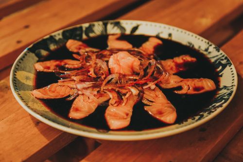 Free Close-up of sashimi salmon with onion and soy dressing on an artistic plate. Stock Photo