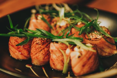 Free Close-up of sushi rolls garnished with fresh greens on a plate. Stock Photo