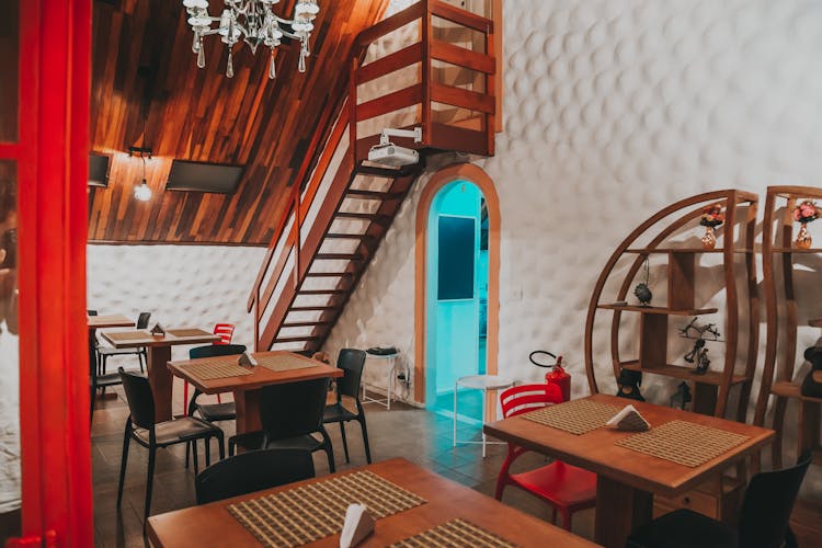 Tables, Chairs And A Staircase In A Restaurant