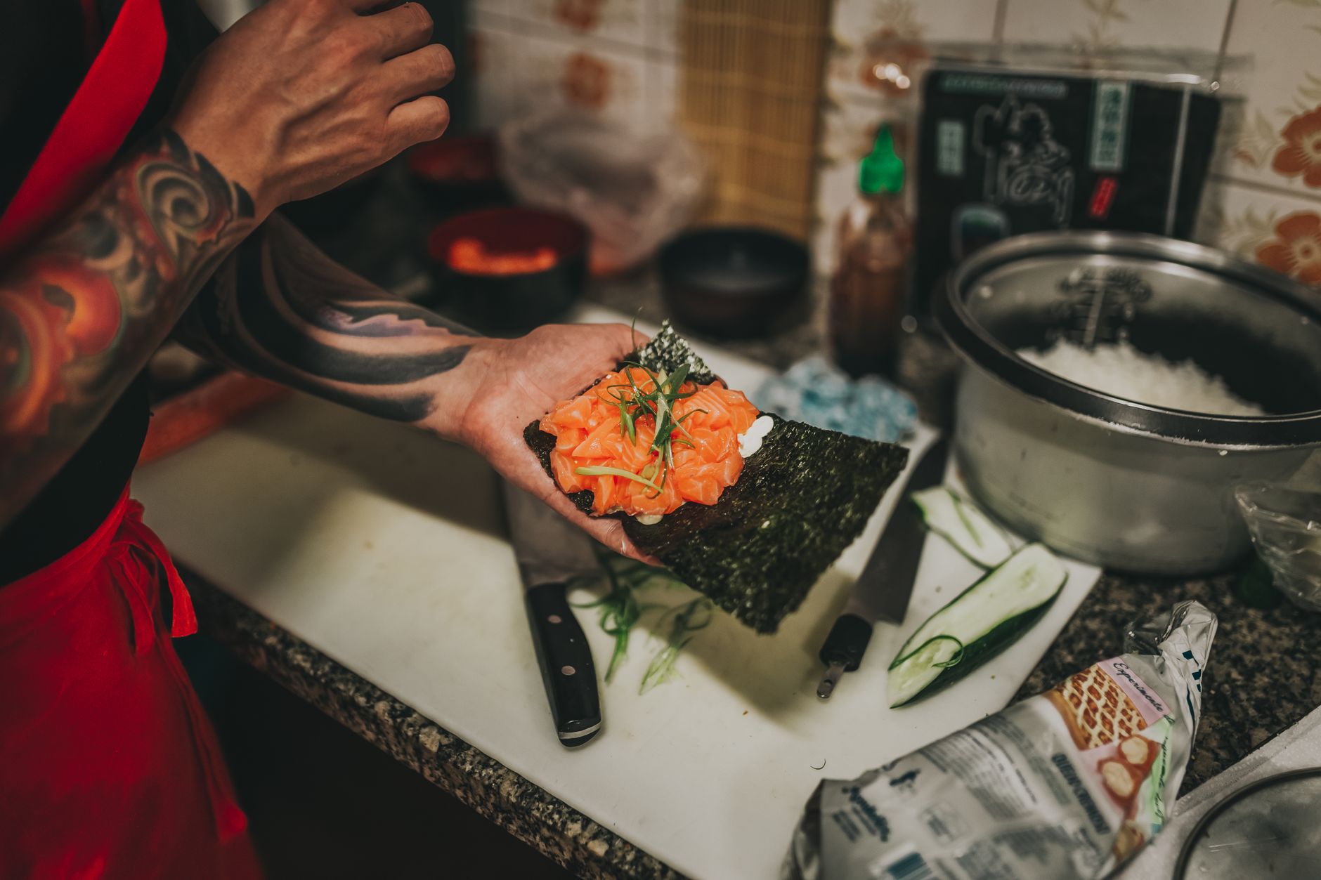 Añadiendo hierbas Manos añadiendo hierbas aromáticas a un plato durante el proceso de cocción