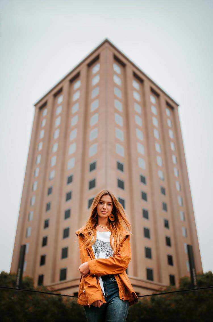 Low Angle View Of A Woman On The Background Of A High Rise Modern Building In City 