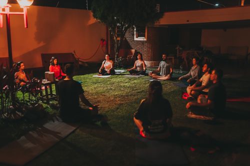 Free A tranquil evening yoga class with diverse adults meditating outdoors on mats. Stock Photo